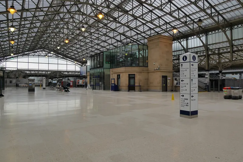 Aberdeen station's wide, bright concourse under a vast arched roof of glass and steel lattice