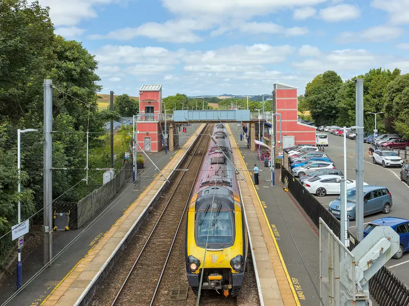 A CrossCountry train at Alnmouth station, seen from the footbridge with its two lift towers