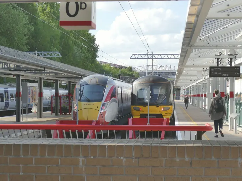 An LNER Azuma and a Northern train side by side under the canopies at Bradford Forster Square, seen from the new platform 0