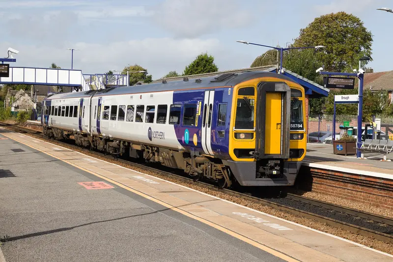 A Northern train at Brough station's platform on a sunny day