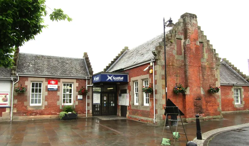 Dunblane's red-brick station building with crowstepped gables and hanging flower baskets