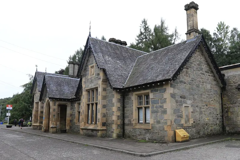 The gabled stone station building at Dunkeld and Birnam with tall chimneys and decorative bargeboards