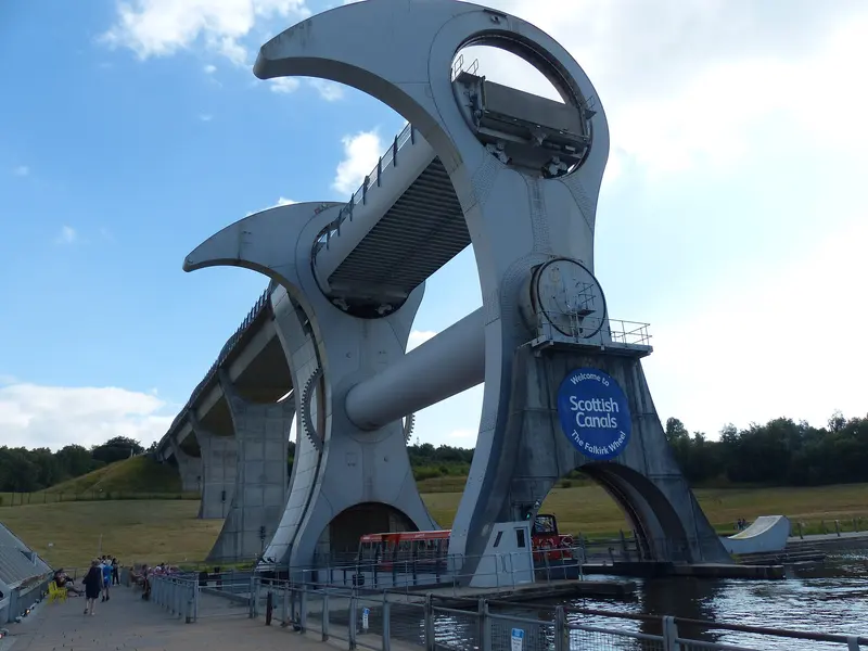 The curved steel arms of the Falkirk Wheel boat lift with its aqueduct behind