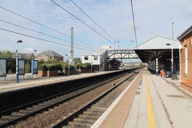 Looking along the platforms at Grantham station, with canopies, a footbridge and overhead wires