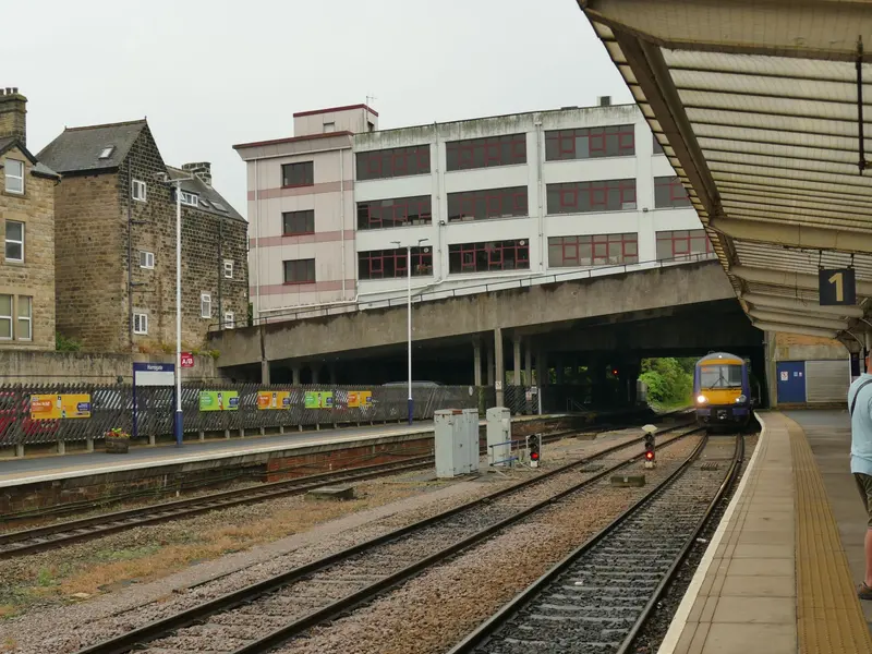 A Northern train arriving at Harrogate station beneath a road deck