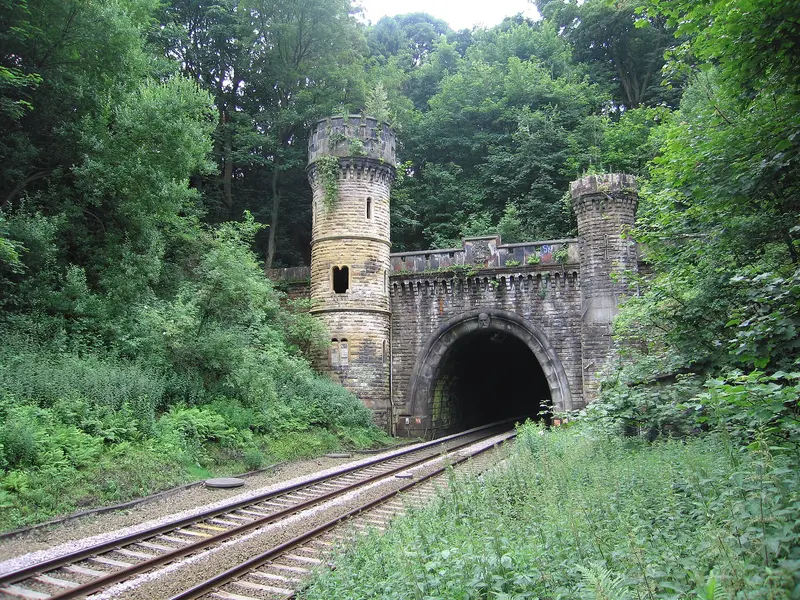 The castellated stone north portal of Bramhope Tunnel with turreted towers above the tracks