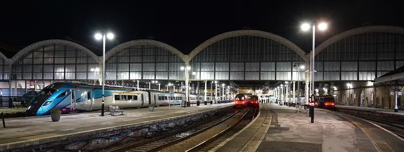The five arched spans of Hull Paragon's train shed lit up at night, with trains at the platforms