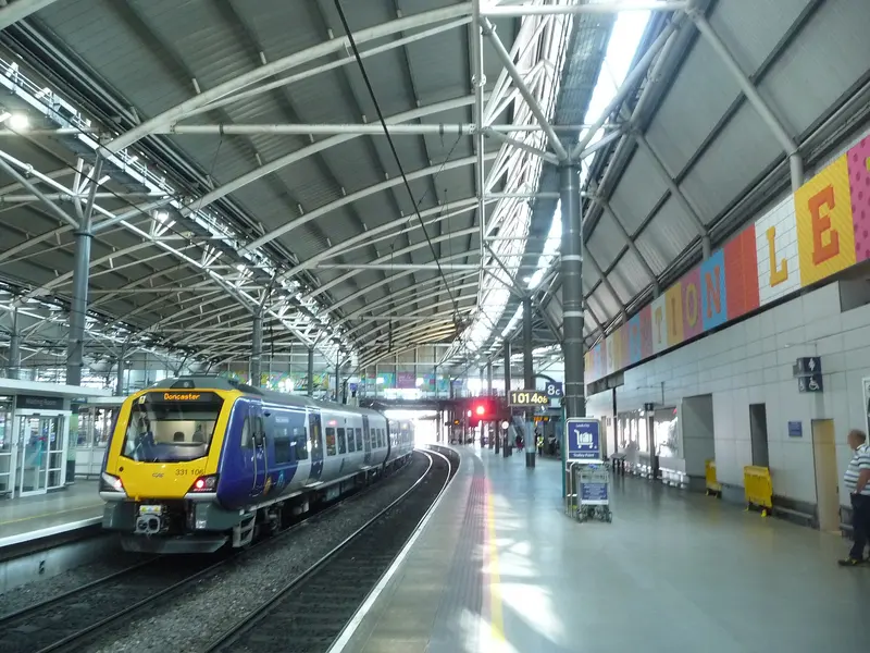 A Northern train at a platform beneath the long glazed roof at Leeds station