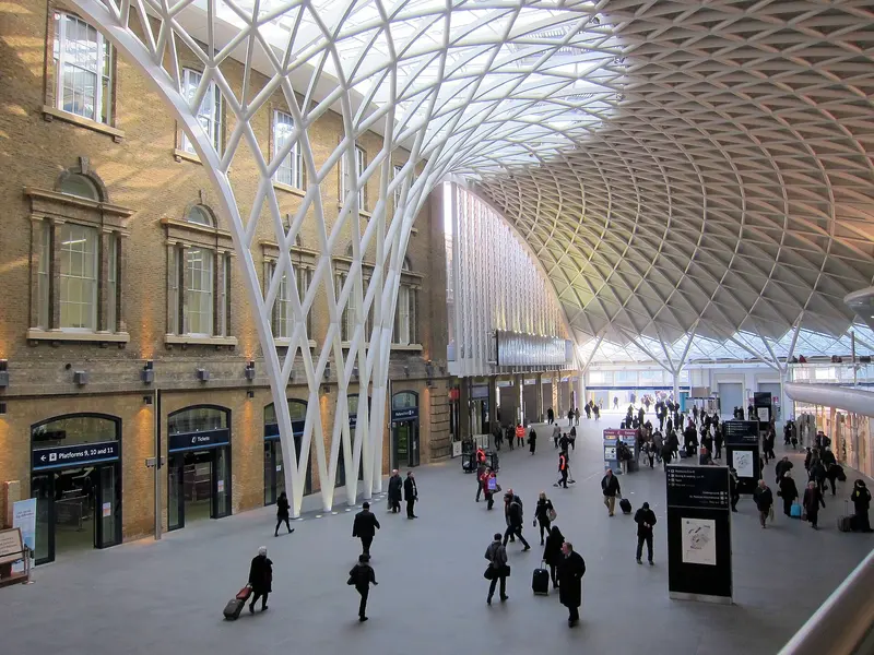 The white lattice roof of the semicircular western concourse at King's Cross fanning out above passengers