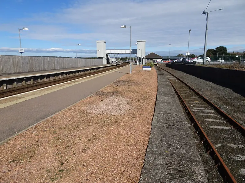 Montrose station's two platforms with the footbridge and its lift towers, and the station building beyond