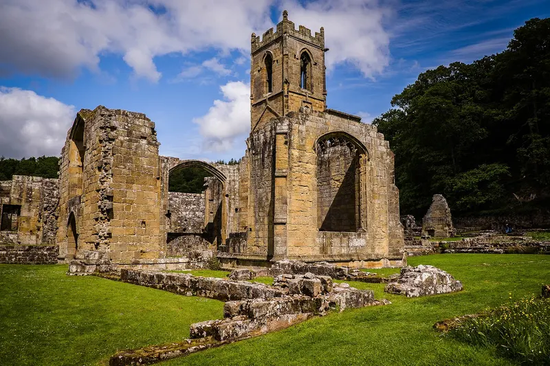 The ruined church tower and walls of Mount Grace Priory on a sunny day