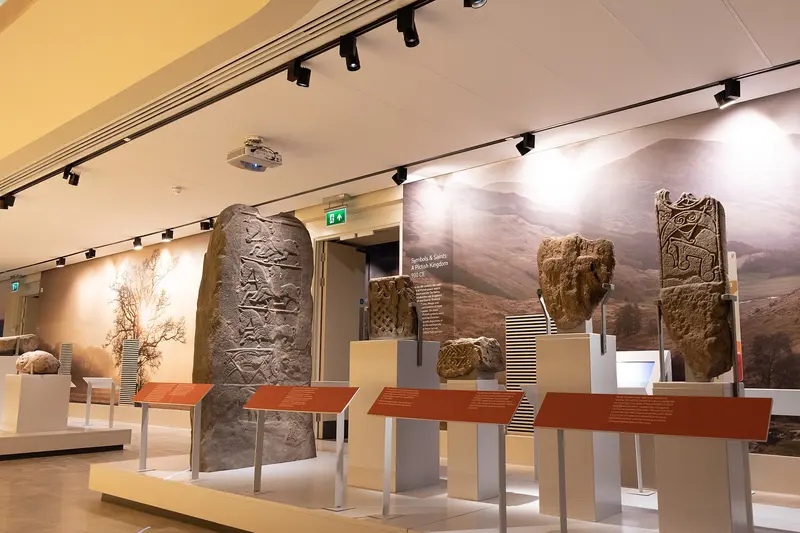 Carved standing stones displayed on plinths in a bright gallery at Perth Museum