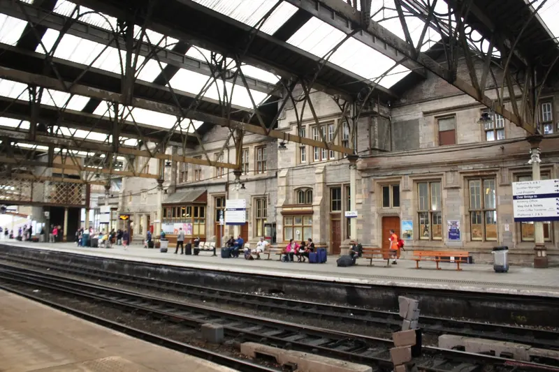 Perth station's stone Tudor-Gothic building beneath the iron and glass roof of the train shed