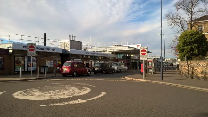 The low modern entrance building of Peterborough station, with taxis waiting in the forecourt