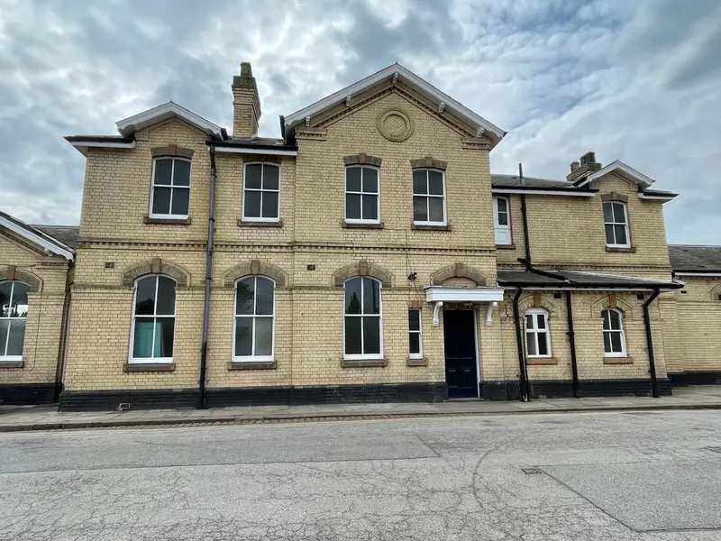 Part of Retford's pale brick Italianate station building, with gables, sash windows and tall chimneys
