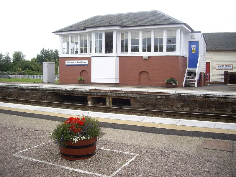 Stonehaven's red-brick and white-timber signal box standing on the platform, seen across the tracks