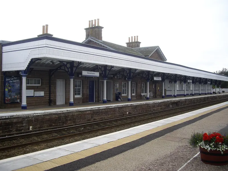 Stonehaven's stone station building with a long white-valanced timber canopy on cast-iron columns along the southbound platform