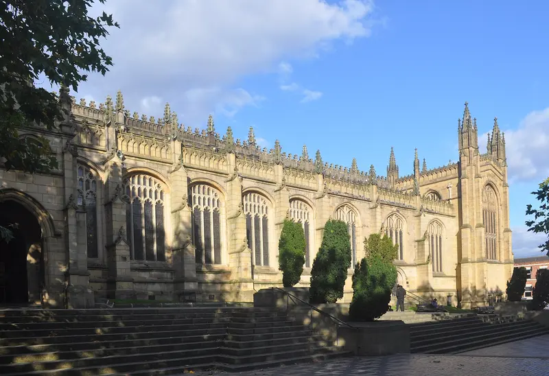 The long Gothic nave and pinnacled tower of Wakefield Cathedral in sunshine, seen from the precinct steps