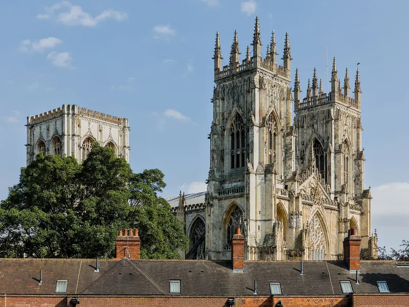 The west towers and central tower of York Minster above a row of rooftops